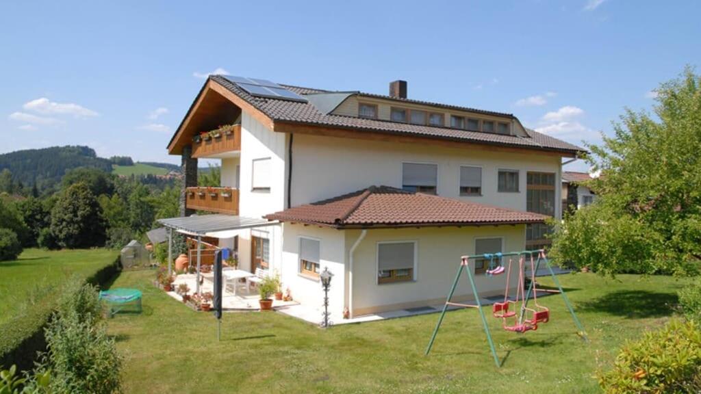 a house with a yard with a playground at Gästehaus Am Ludwigsberg in Bad Koetzting