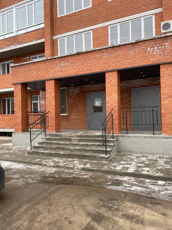um edifício de tijolos com escadas em frente em Современная квартира в новом доме em Pavlodar