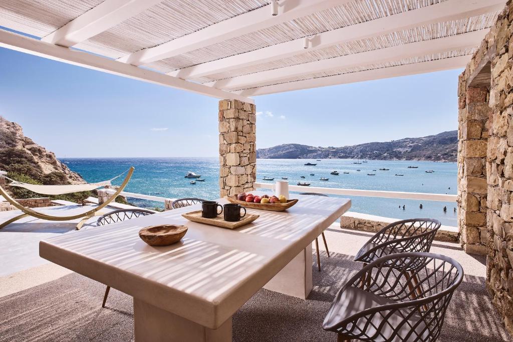 a white table and chairs on a patio with the ocean at Ninos Houses in Provatas