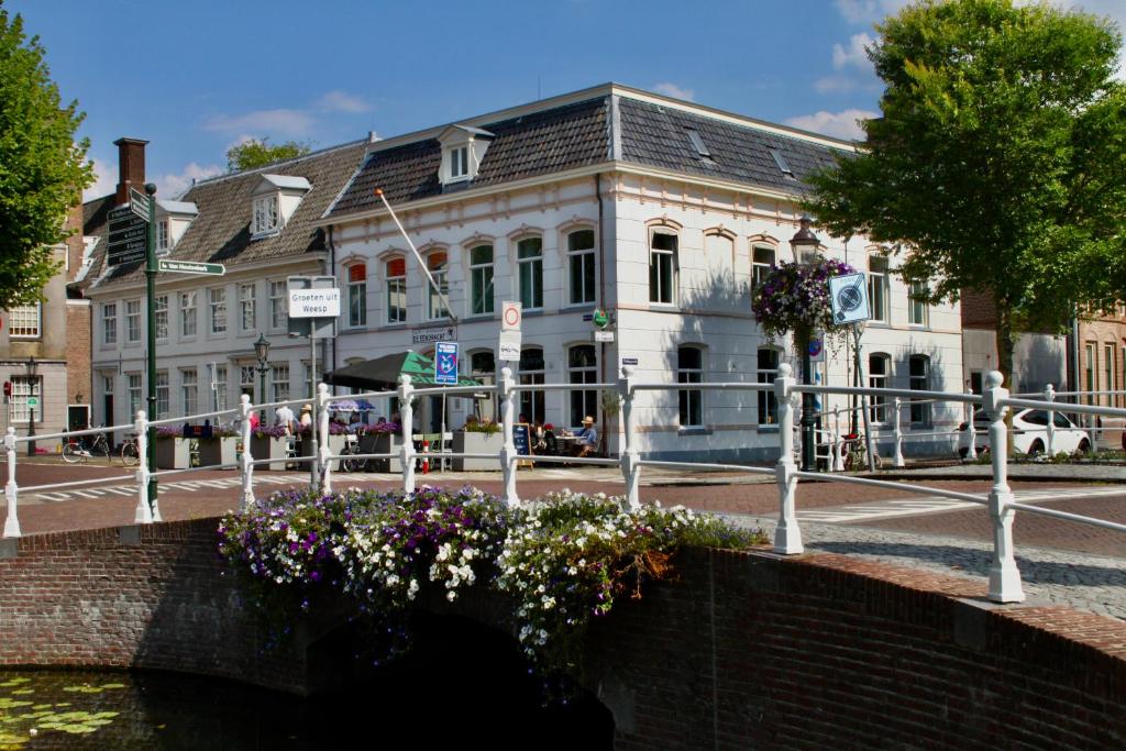 un ponte su un fiume di fronte a un edificio di Boutique Hotel Weesp a Weesp