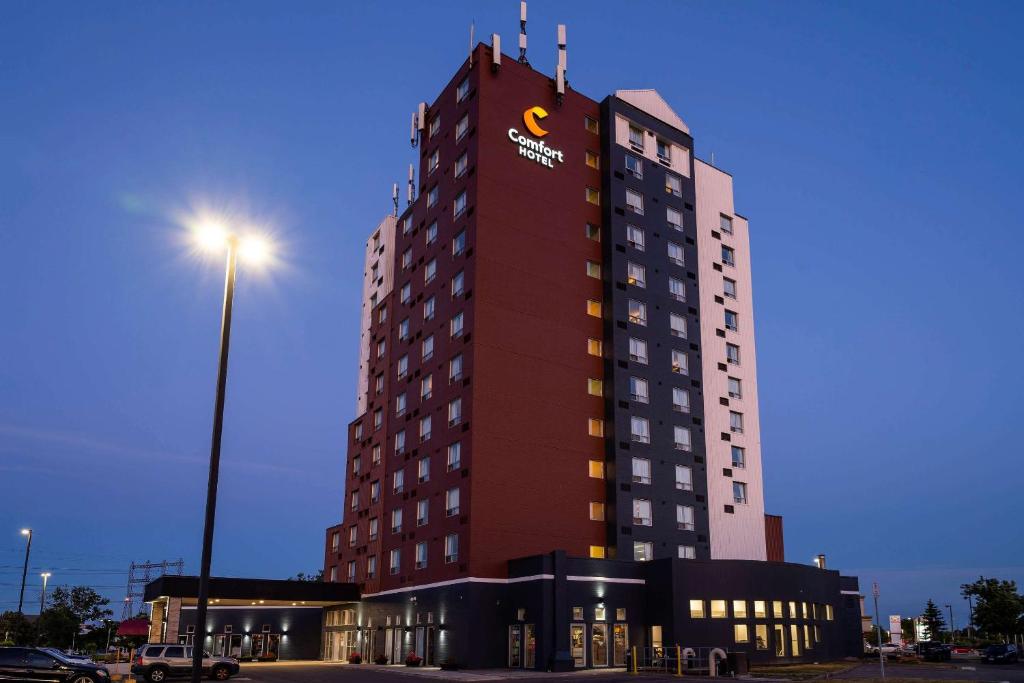 a tall building with a sign on the top of it at Comfort Hotel Airport North in Toronto