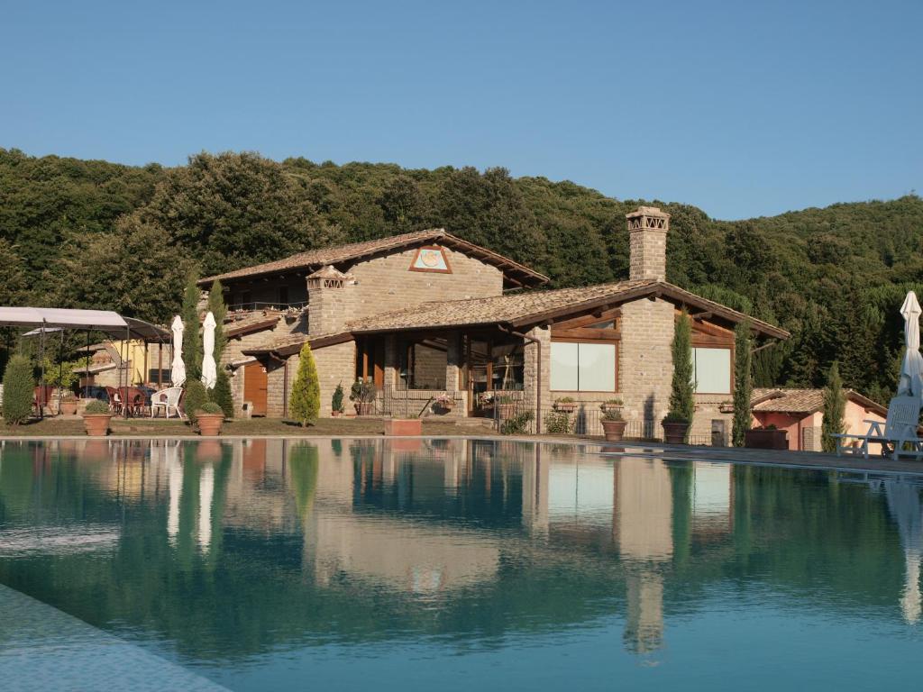 a house with a large pool of water in front of it at Residenza di Rocca Romana Holiday Home in Trevignano Romano