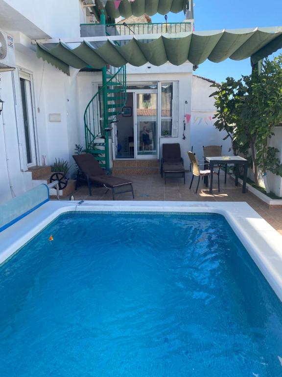 een zwembad met een patio met een tafel en een trap bij The hidden Place in Alcaudete