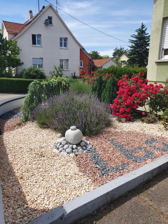 einen Garten vor einem Haus mit Blumen in der Unterkunft Le Havre in Blotzheim