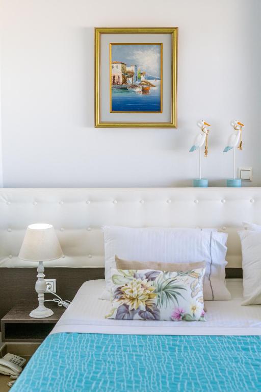 a bedroom with a bed with a picture on the wall at 3Aktes Suites & Studios in Syvota