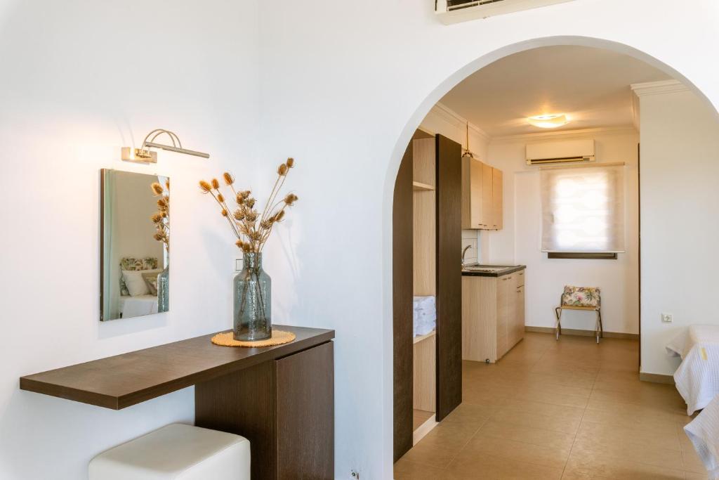 a room with a table and a vase with flowers on it at 3Aktes Suites & Studios in Syvota