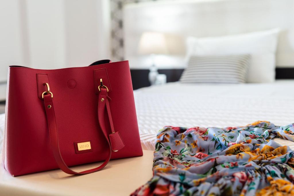 a red purse sitting on a table next to a bed at 3Aktes Suites & Studios in Syvota