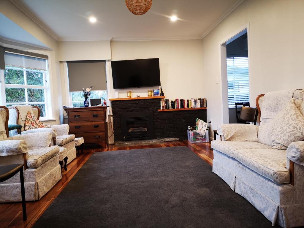 a living room with two couches and a flat screen tv at Cheerful 4 Bedroom Holiday Home (Sleeps 7) in Rotorua