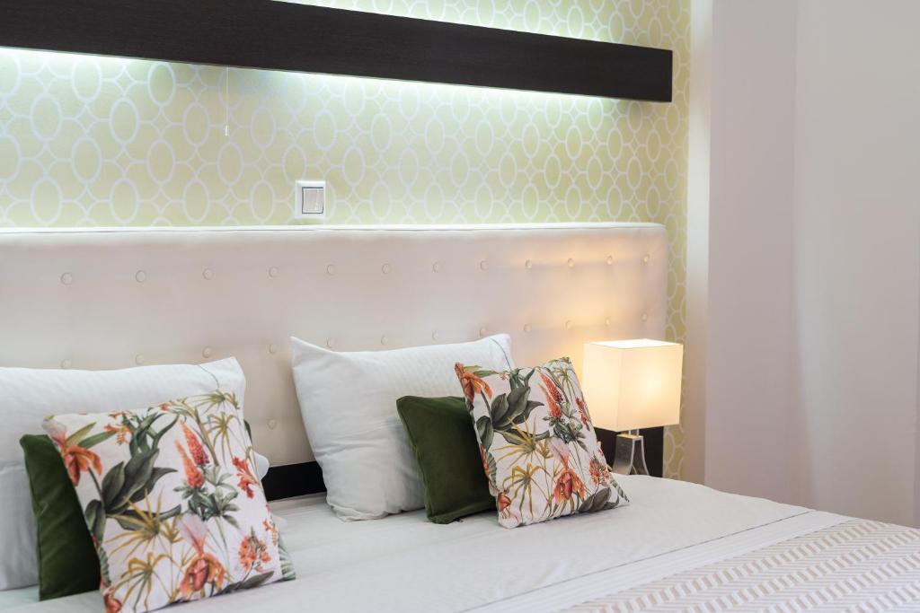 a bedroom with a white bed with pillows at 3Aktes Suites & Studios in Syvota