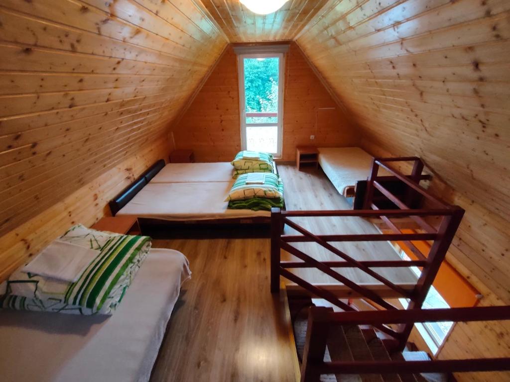 a room with three beds in a wooden cabin at Gospodarstwo Agroturystyczne na Górce in Myczkowce