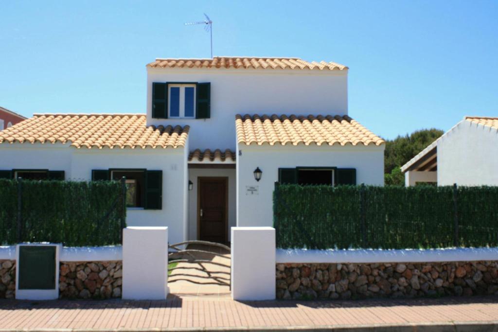 a white house with a red roof at Grupoandria Villa TIERRASOL, Ciutadella in Cala en Blanes