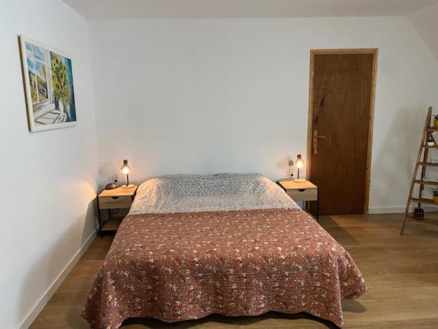 a bedroom with a bed with two tables and two lamps at Maison de Campagne in Sarroux