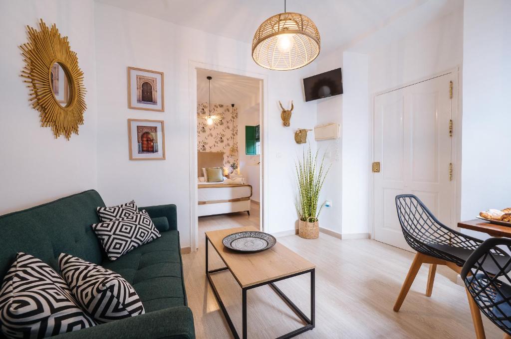 a living room with a green couch and a table at Apartamento San Eloy in Seville