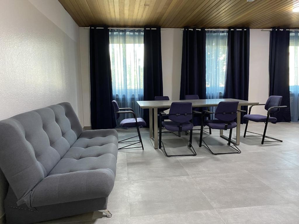 Una sala de estar con un sofá, una mesa y sillas. en Kaiserswerth, en Düsseldorf