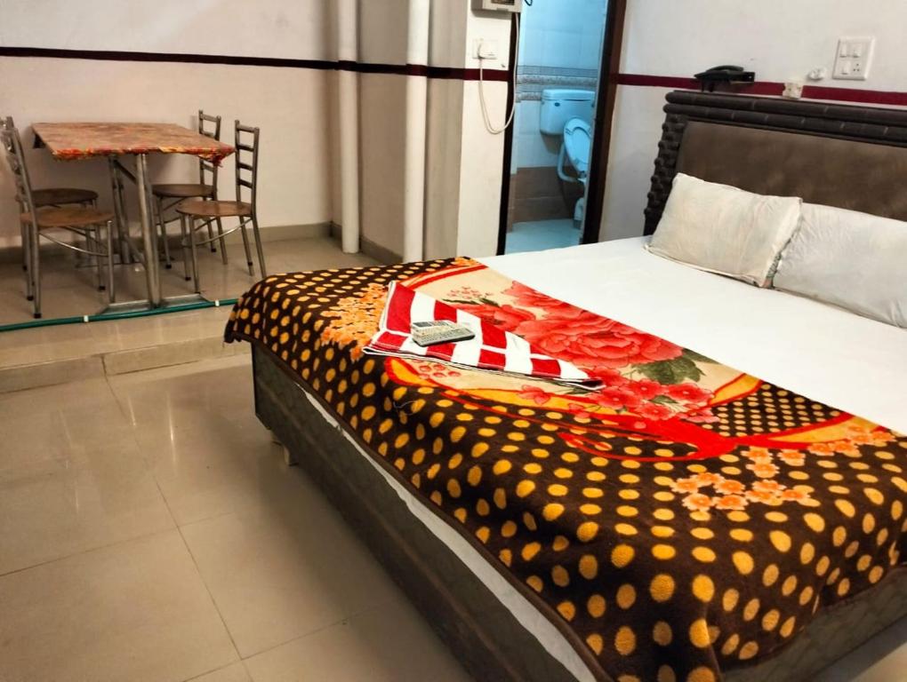 Bett in einem Zimmer mit Tisch und Stühlen in der Unterkunft Hotel Anta Palace & Spicy Restaurant By WB Inn in Bharatpur