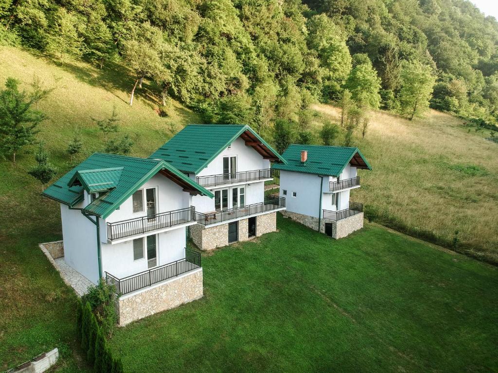 uma vista aérea de duas casas com telhados verdes em Idyllic river front holiday houses - Tišine em Goražde