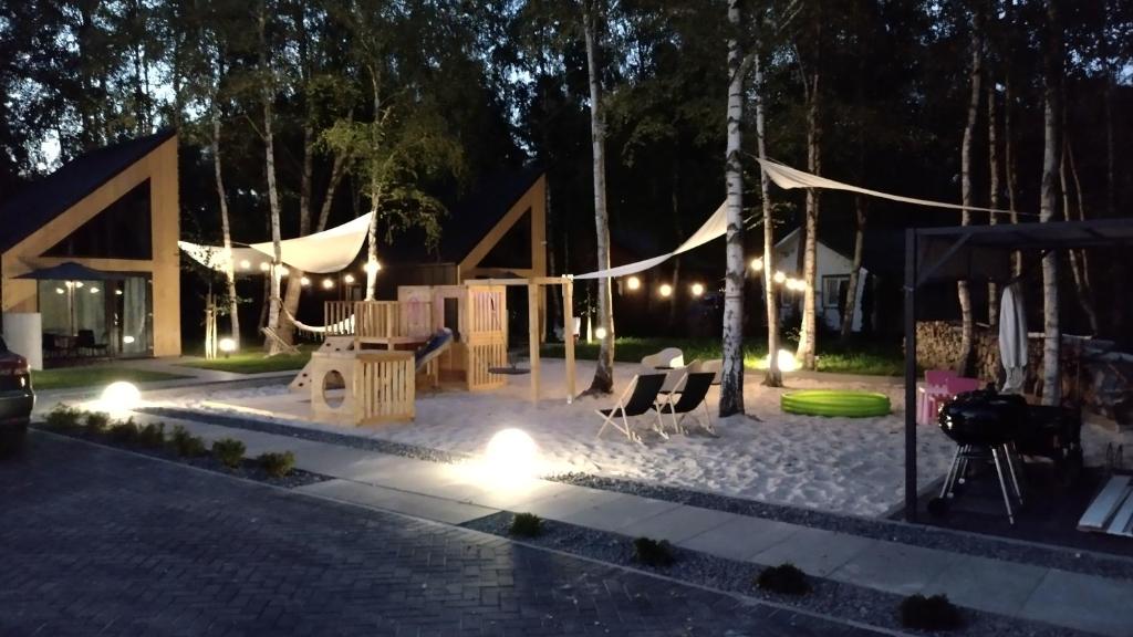 a playground at night with lights and a tent at Village Mielno - najpiękniejsze domki wakacyjne nad morzem in Mielno