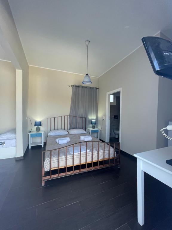 a bedroom with a bed and two tables in it at AEGEAN VIEW SEASIDE ROOMS AND STUDIOS KEA in Korissia
