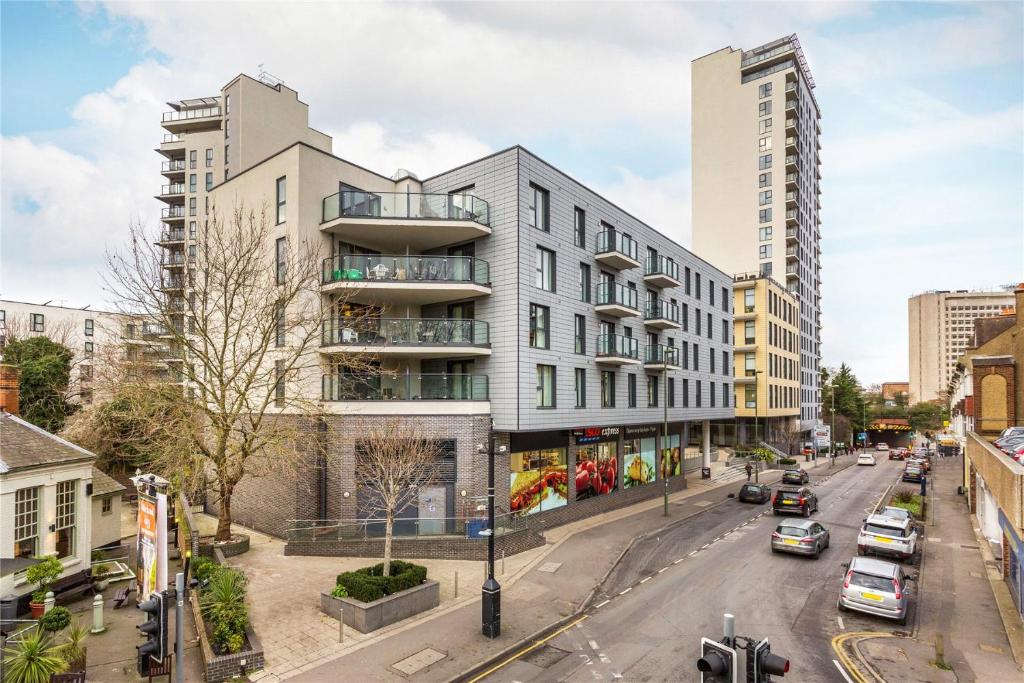 ein Gebäude in einer Stadtstraße mit parkenden Autos in der Unterkunft Cloud9SA at Woking Central in Woking