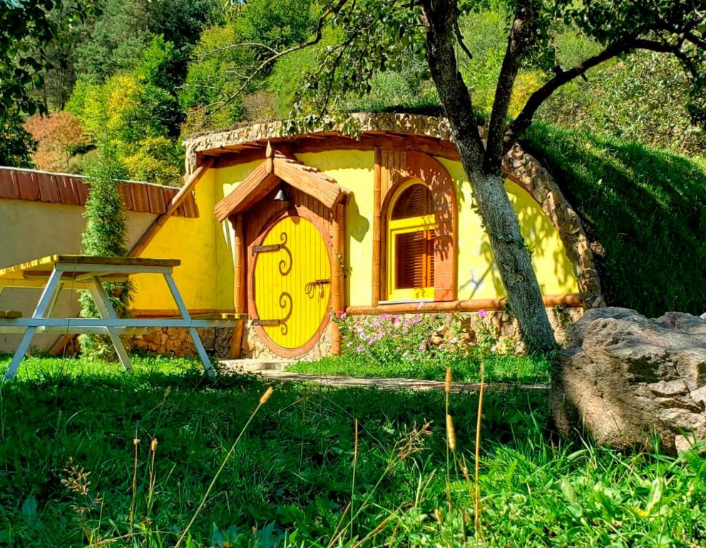 Una pequeña casa con un reloj al costado. en Cozy House, en Dilijan