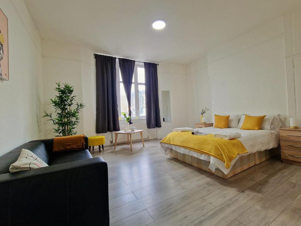 una camera con un letto e un divano di Spacious 4 Bedroom apartment in amazing location a Londra