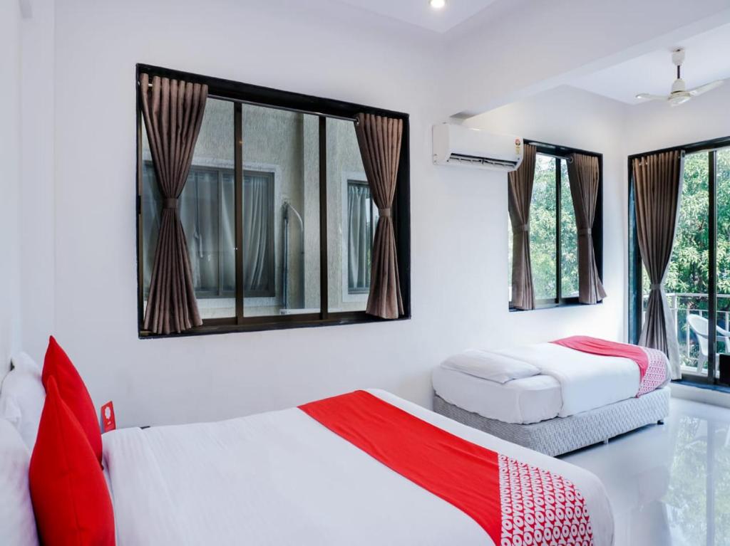 1 dormitorio con 2 camas y 2 ventanas en DREAM HOLIDAYS RESORT, en Lonavala