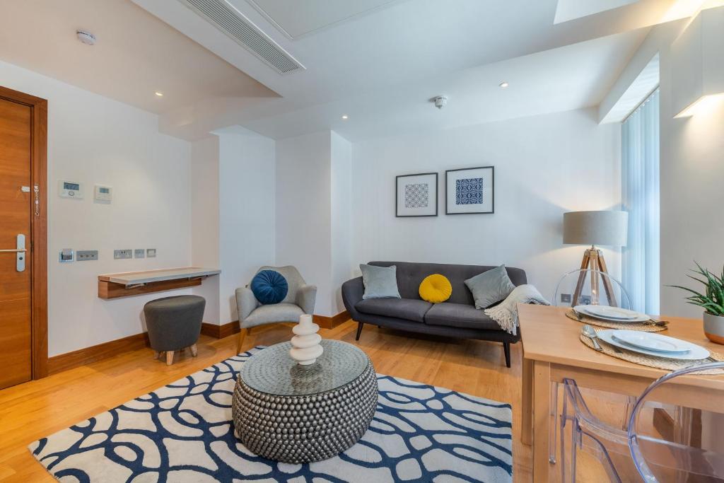 a living room with a couch and a table at Studio - Tower Hill - City Centre by Prime London Stays N-5 in London