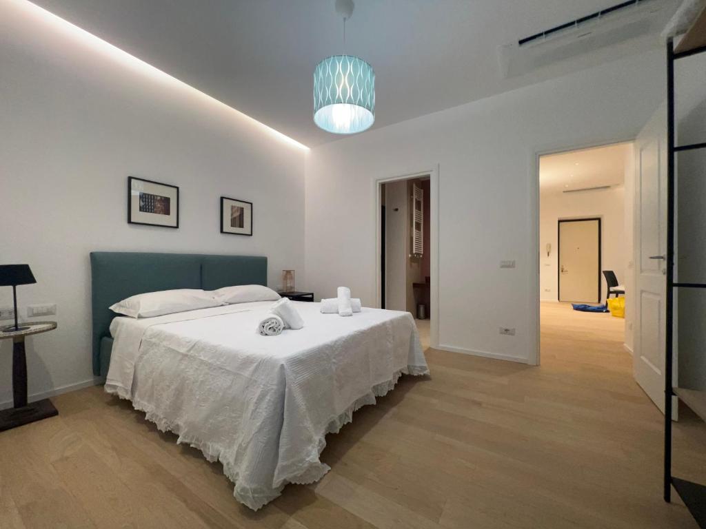 - une chambre blanche avec un grand lit et une tête de lit bleue dans l'établissement AT HOME NAVONA, à Rome