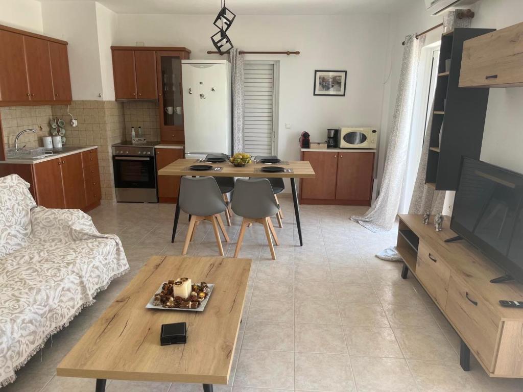 ein Wohnzimmer mit einem Sofa und einem Tisch mit Stühlen in der Unterkunft S&G Luxury Apartments - Makri Gialos in Makry Gialos