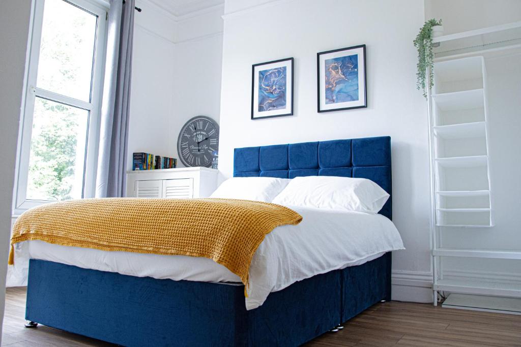 a blue bed in a white bedroom with a blue headboard at Central Dover - 1 Bedroom apartment in Kent