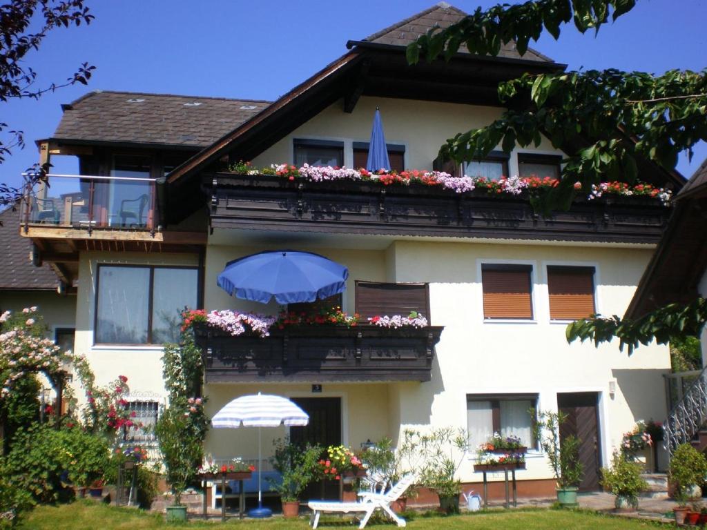 un bâtiment avec un balcon fleuri et un parasol dans l'établissement Apartments Blaschegg im Zentrum, à Altmünster