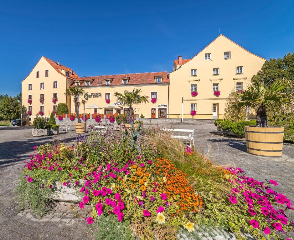 un edificio con un jardín de flores delante de él en Spa Hotel Centrum en Františkovy Lázně