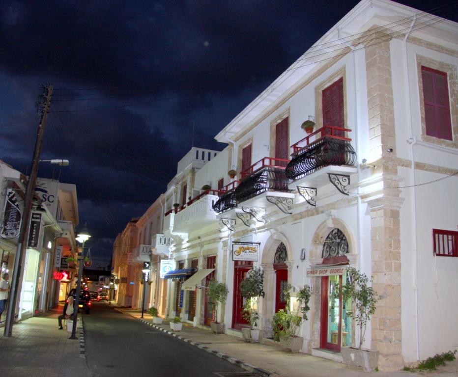 uma rua da cidade à noite com um edifício branco em Kiniras Traditional Hotel & Restaurant em Pafos