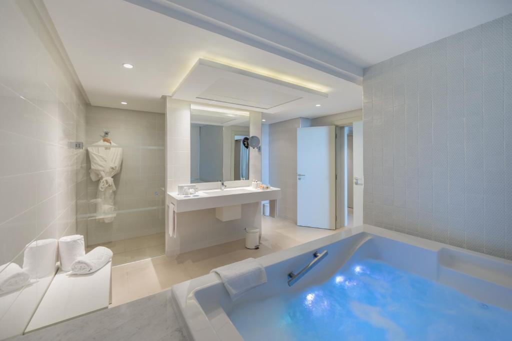 a bathroom with a large tub and a sink at Royal Azur Thalassa in Hammamet