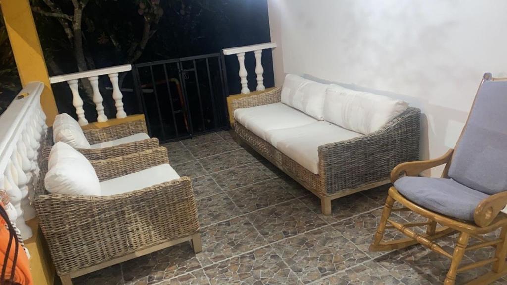 drie rieten stoelen en een bank op een balkon bij CASA DE CAMPO Villa Ibiza - EXCELENTE DESCANSO in Betulia