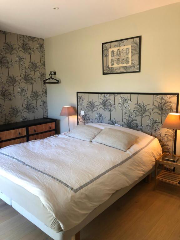a bedroom with a large white bed in a room at Chambre d'Hôte Touquet's Garden in Cucq