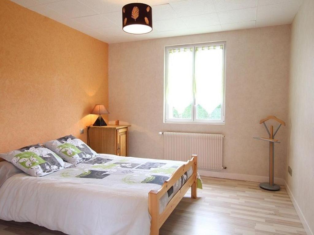 sypialnia z dużym łóżkiem i oknem w obiekcie Charmante Maison Traditionnelle avec Jeux, Terrasse et Parking à Lantriac - FR-1-582-78 w mieście Lantriac