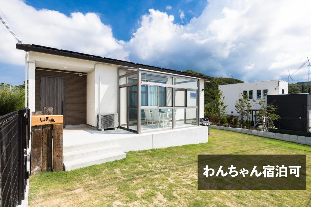 ein modernes Haus mit Glasfassade in der Unterkunft しっぽの森リゾート淡路島〜サウナ&スタジオ〜 in Awaji