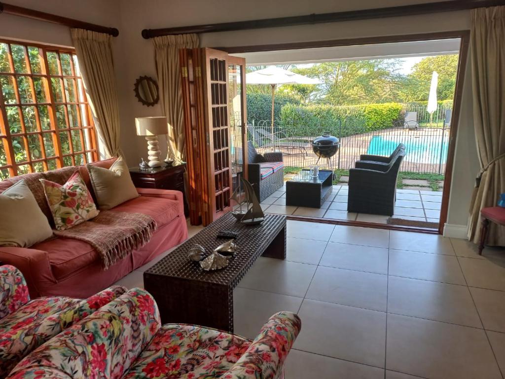 een woonkamer met een bank en een tafel bij Pearl Cottage in Durban