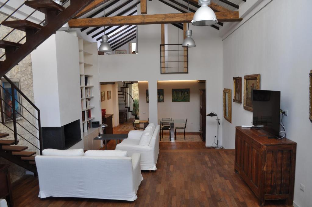 een woonkamer met witte banken en een tv bij Casa di Mario appartamento in centro storico con due camere da letto e terrazze in Cagliari