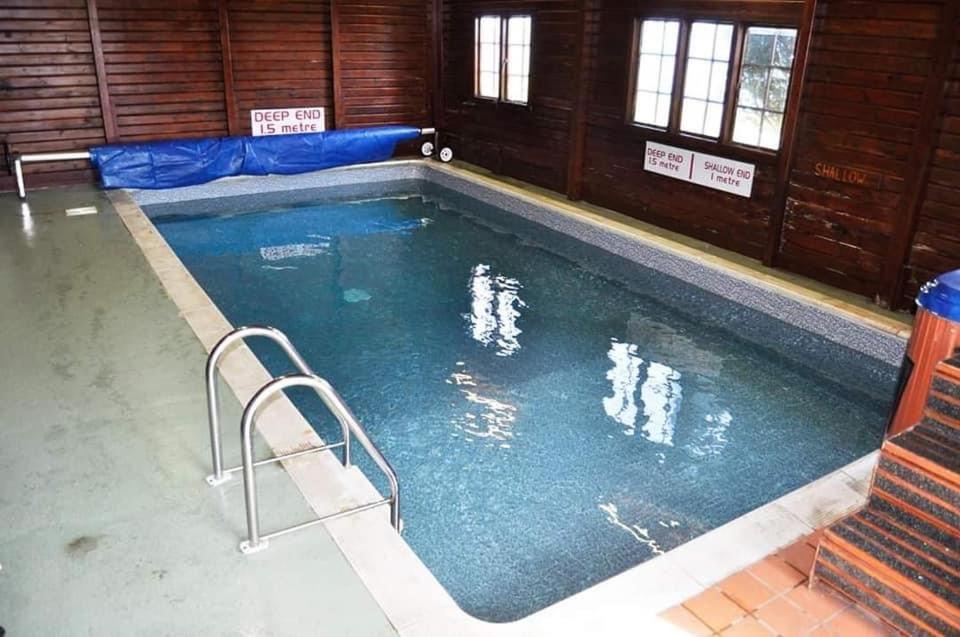 uma grande piscina com duas pessoas na água em 47 Lochview em Stranraer