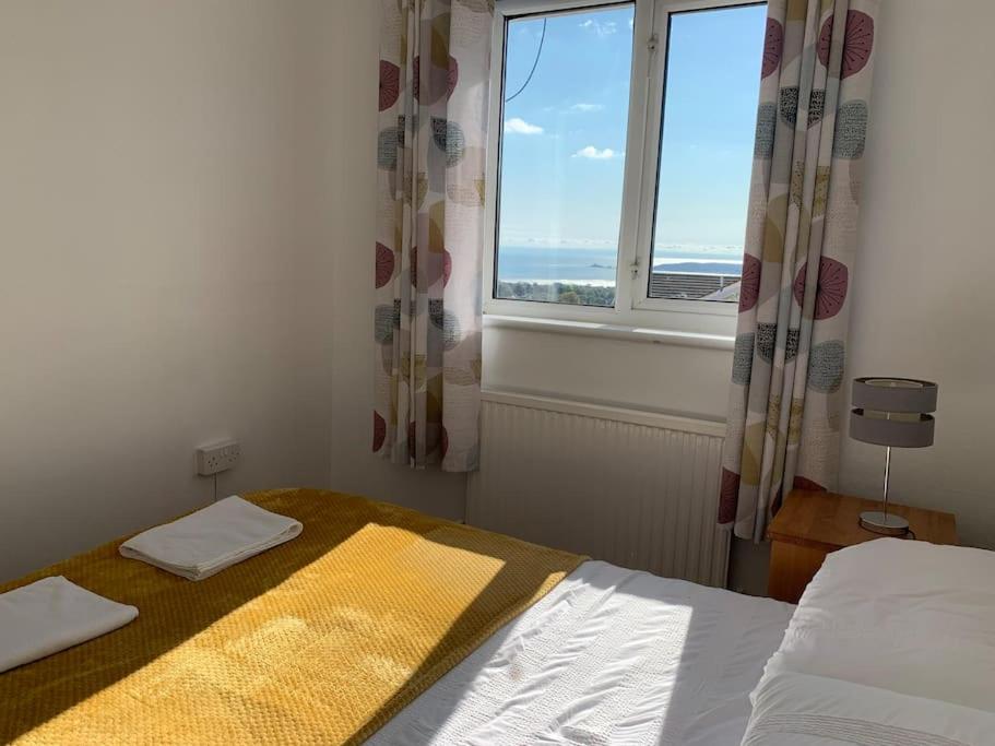 a small bedroom with a bed and a window at Modern & Light with Sea Views & Parking, Swansea in Dunvant