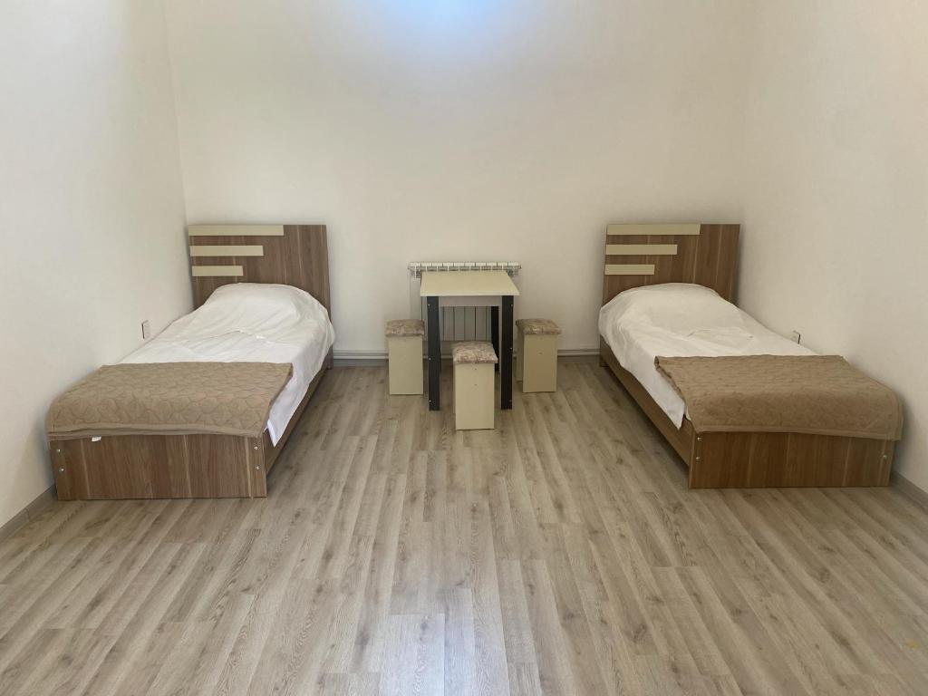 Duas camas num quarto com pisos em madeira em Zig Residence em Baku