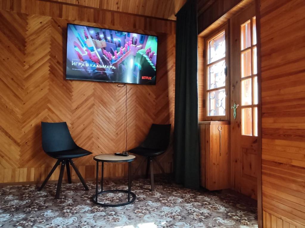 2 chaises et une télévision sur un mur en bois dans l'établissement EXCLUSIVE HOUSE 400m2 - Sauna, BBQ, fireplace, à Narva