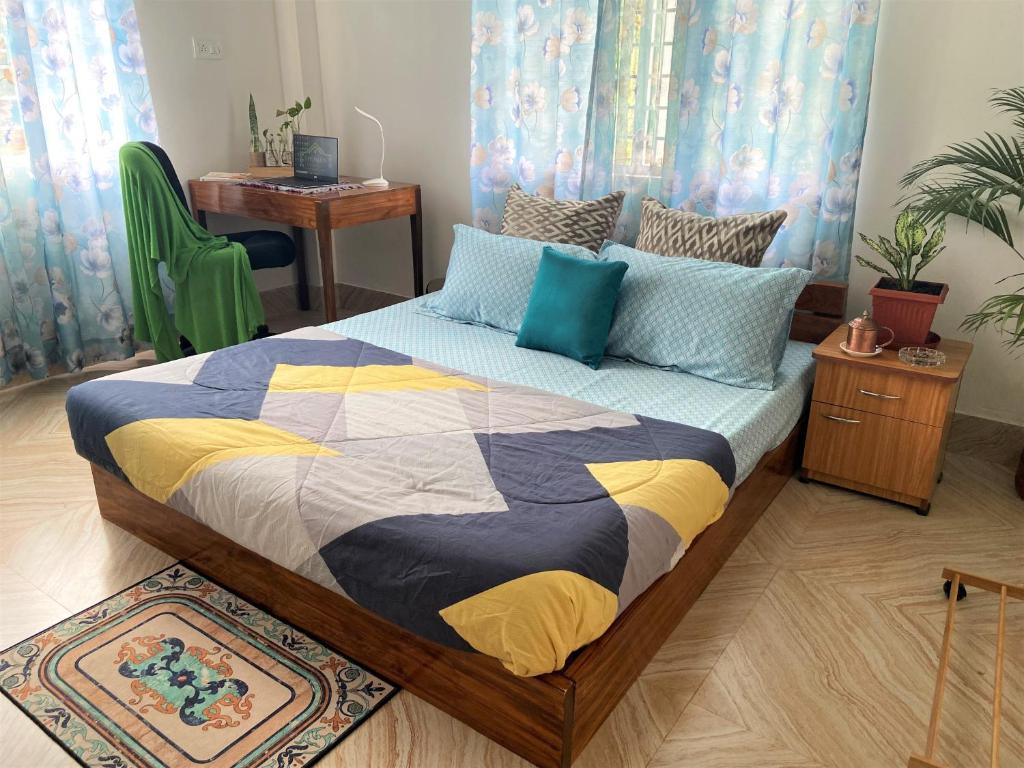 Bhuman Homestay في سيليغري: غرفة نوم مع سرير ولحاف ملون عليها