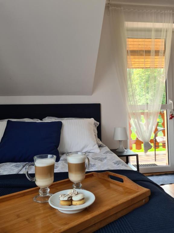a tray with two cups of coffee on a bed at Apartament Katarina 2 in Ustrzyki Dolne