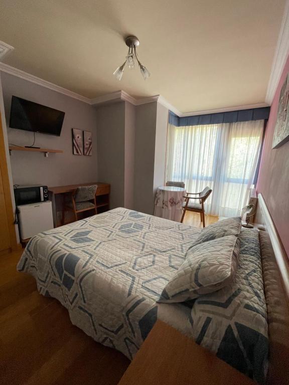 een slaapkamer met een bed, een tafel en een raam bij Hostal Santiago 2 in Burgos