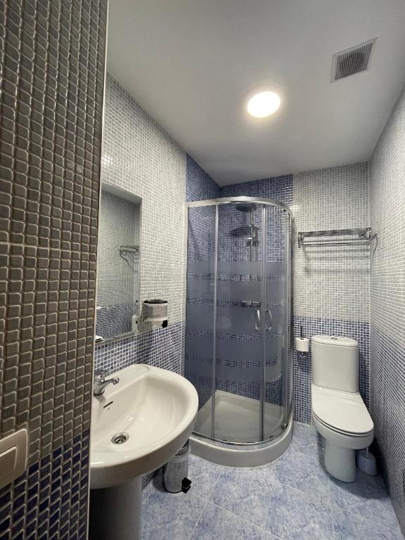 Un baño con ducha, lavabo e inodoro. en Hostal Santiago 2, en Burgos