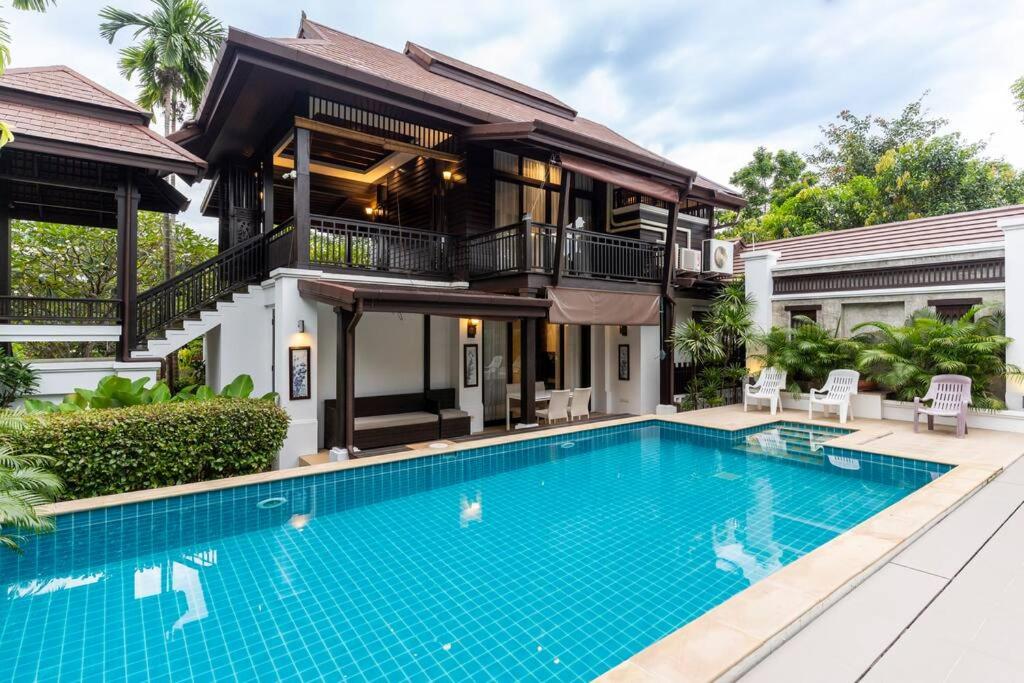 a villa with a swimming pool in front of a house at Sclass Villa & Swimming pool , 10 min from airport in Chiang Mai