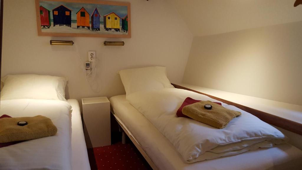 a small room with two beds and a painting on the wall at Botel Liza Marleen in Amsterdam